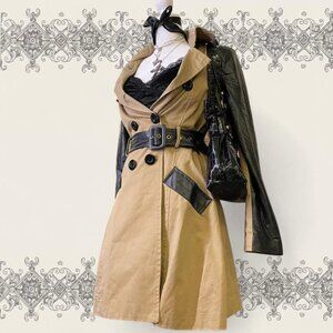 Tan trench coat with black leather sleeves and belt